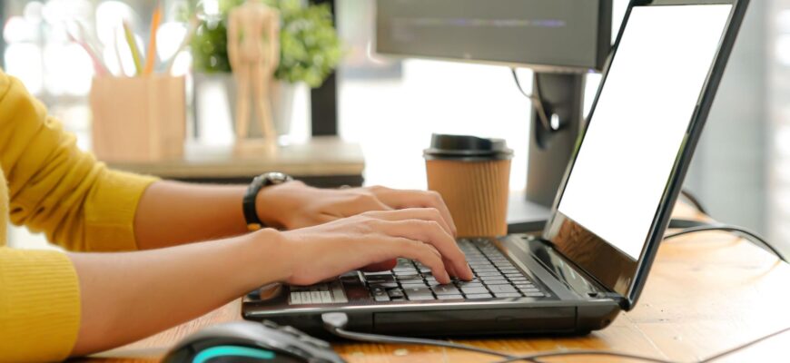 Фото девушка за рабочим столом работает с ноутбуком